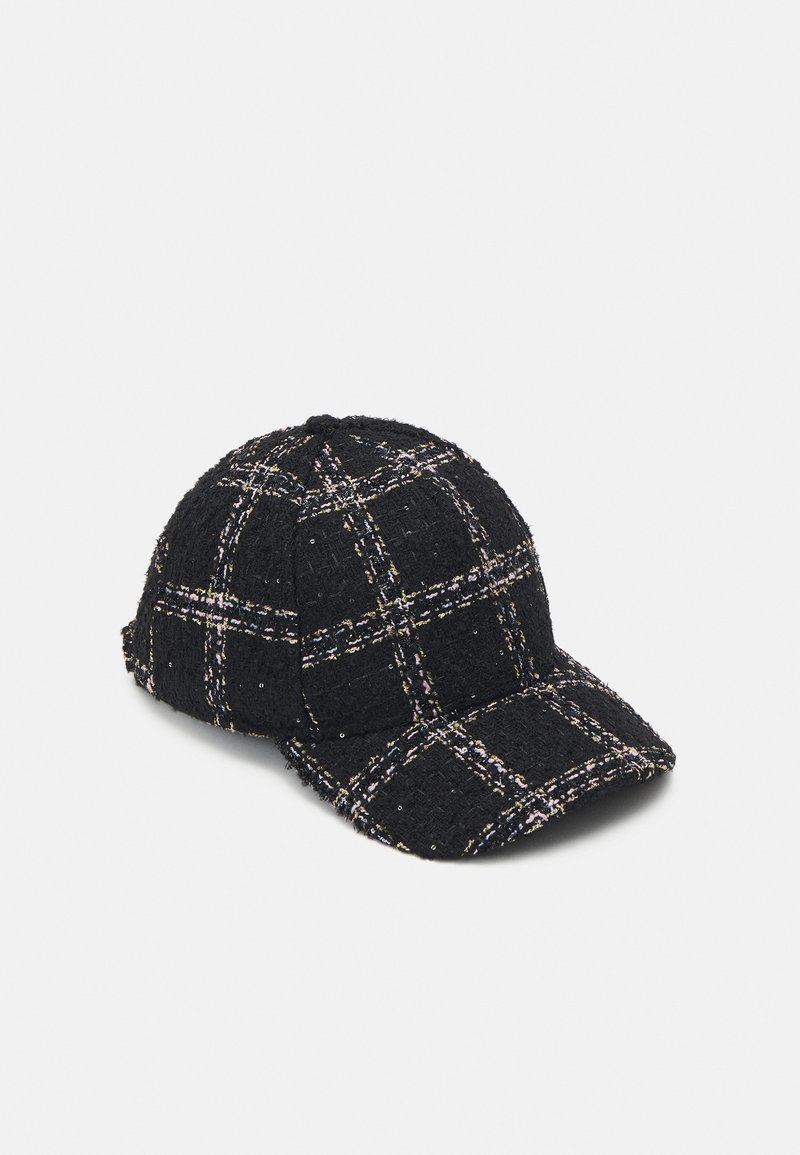 Casquette de baseball noire texturée avec motif à carreaux blancs et roses et petites paillettes sur un fond clair uni.