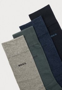 Patru perechi de șosete: gri, verde, bleumarin și negru. Amestec de bumbac cu textură ribată. Fiecare prezintă un logo subtil 'BOSS' aproape de manșetă.