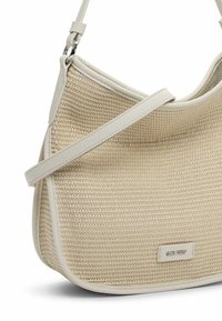 Borsa beige intrecciata con silhouette curva, dettagli in pelle e una lunga tracolla regolabile. Presenta un branding sottile sul fronte.
