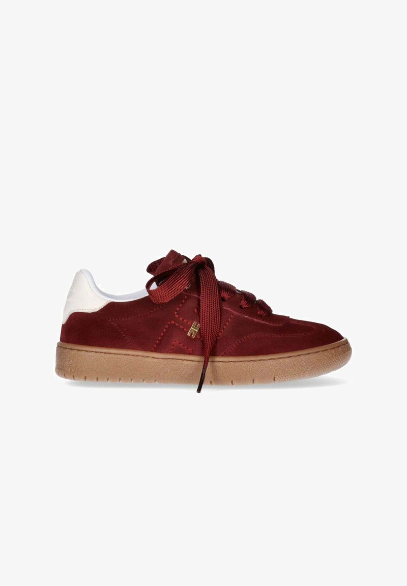 Sneakers in suede rosso con tallone in pelle bianca, suola in gomma marrone e lacci tonalità. Presentano dettagli trapuntati e un accento con logo dorato.