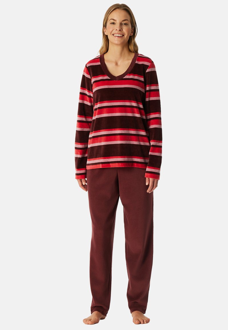 Top de manga larga a rayas rojas y marrones con escote en V, combinado con pantalones burdeos lisos, ambos en un tejido suave parecido al forro polar.