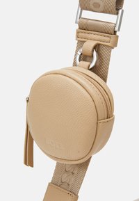 Rund beige läderpung med dragkedja, fäst vid ett strukturerat beige band, med silverfärgad hårdvara och en präglad logotypdetalj.