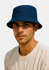 Navy blue bucket hat made of textured fabric, featuring a wide brim and a structured design, worn with a light-colored t-shirt.
