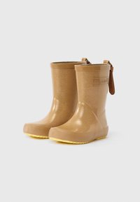 Világosarany színű, csillogó gyermek esőcsizmák sárga talppal és húzófülekkel, fehér háttéren, dombornyomott "bisgaard" logókkal márkajelzéssel.