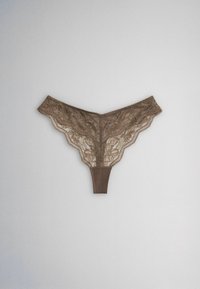 String en dentelle marron avec broderie florale, présenté à plat sur un fond gris clair uni.