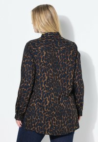 Camicia a stampa leopardata in blu e marrone, con colletto classico, maniche lunghe e vestibilità rilassata. Il materiale sembra leggero con una consistenza liscia.