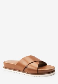 Bruine leren slidingsandalen met kruisbanden, gevoerde binnenzool en witte getande buitenzool. Glad oppervlak met contrasterende stiksels.