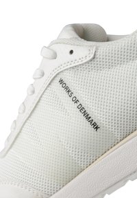 Zapatilla de malla blanca con parte superior texturizada, cierre de cordones y marca negra contrastante "WORKS OF DENMARK" en el lateral. Suela de goma.