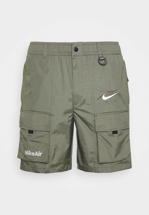 Oliwkowe krótkie spodenki Nike Air cargo z elastycznym pasem, zapięciem na guziki, dużymi przednimi kieszeniami, nadrukami z logo i małą czarną pętelką blisko talii.