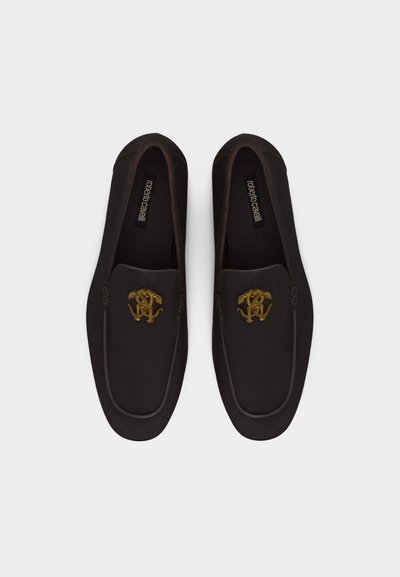 Ζευγάρι μαύρα δερμάτινα μοκασίνια με χρυσό κεντημένο λογότυπο στο πάνω μέρος, απόψη σε λευκό φόντο.