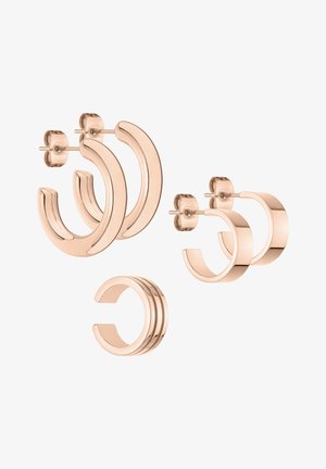 Set van drie paar roségouden oorbellen in verschillende vormen: grote ringen, subtiele studs en een drievoudige band; gladde textuur, glanzende afwerking.