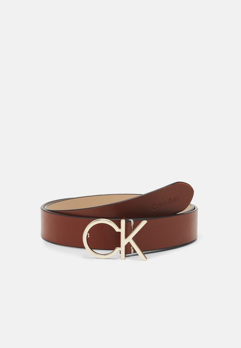 Ceinture en cuir marron enroulée avec boucle logo CK dorée et nom de la marque Calvin Klein embossé à l’extrémité intérieure de la ceinture.
