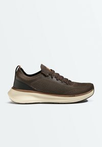 Baskets montantes marron en maille avec lacets, détail talon noir et semelle blanche épaisse étiquetée Corexfoam, présentées de profil sur fond blanc.