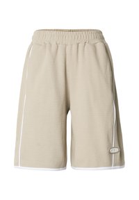 Beige waffle-textured shorts with an elastic waistband, white side piping, and a small brand logo on the lower front left side.