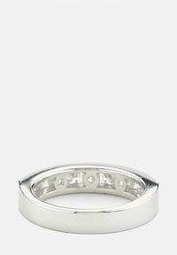 Sidabrinis žiedas su lygiu, poliruotu paviršiumi. Turi siaurėjantį dizainą ir eilę skaidrių brangakmenių įmontuotų viduje.