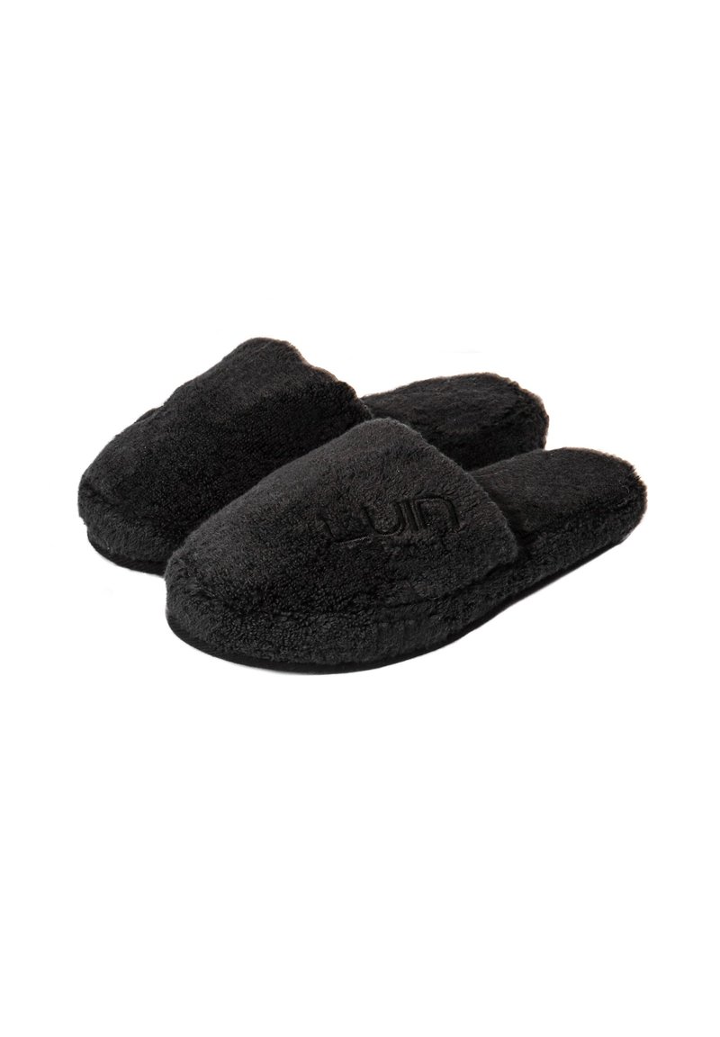 Svarta fluffiga tofflor med en plyschkänsla, öppen tå-design och broderad logotyp. Rundad form med ett mjukt, bekvämt utseende.