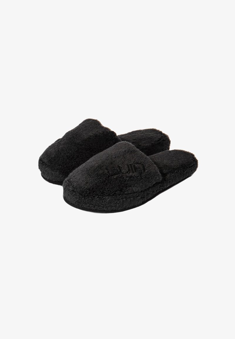 Musta karvainen tossut, joissa on pehmeä pinta, avonaiset varpaat ja brodeerattu logo. Pyöreä muoto ja pehmeä, mukava ulkonäkö.