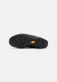 Juodas guminis padas su šiurkščiu, tekstūruotu raštu ir geltonu Vibram logotipu. Viršutinis sluoksnis pasižymi raudonais ir baltais akcentais bei struktūrizuotu dizainu.
