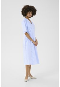 Pasižen midi obleka v modro-belih črtah s kratkimi rokavi, V-izrezom in A-line silhueto, v kombinaciji s svetlimi balerinkami.