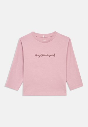 Pink long-sleeve shirt with round neck and centered cursive text saying "Always Believe in yourself" on the front.