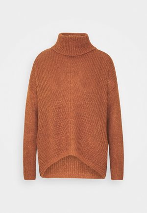 Pull à col roulé en maille de couleur rouille avec manches longues et ourlet légèrement asymétrique sur un fond uni.