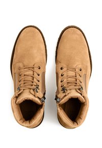 Lysebrune ruskind ankelstøvler med rund tå, snørelukning og metal-accenter. Har polstret krave og sidepaneler for komfort.