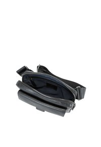 Zwarte leren crossbodytas met een ritssluiting voor het hoofdvak en een verstelbare riem. Het interieur heeft een donkere stoffen voering en kaartvakken.