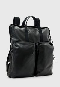 Černý kožený batoh s dvěma předními zipovými kapsami, pevnými látkovými popruhy a hladkým povrchem. Má logo vyražené na přední straně.