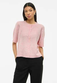 Cardigan rosa tenue in maglia leggera, con collo tondo, maniche corte e bottoni perlacei lungo il davanti. Finitura testurizzata distintiva.