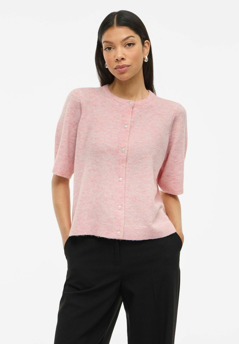 Mjuk rosa kofta i lättstickad kvalitet, med rund hals, korta ärmar och pärlknappar framtill. Distinkt strukturerad yta.
