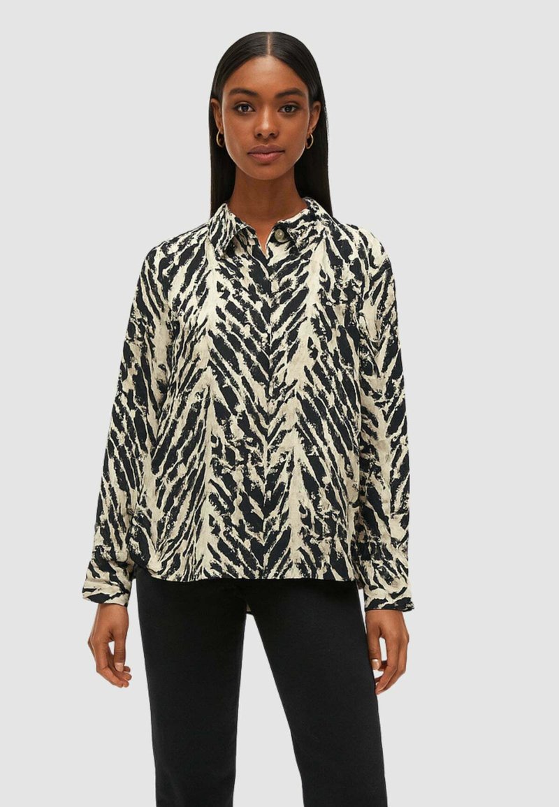 Blusa a maniche lunghe color crema con motivo astratto nero, colletto con bottoni, vestibilità rilassata e tessuto morbido e leggero.