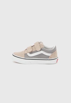 Baskets basses gris et beige avec bande blanche sur le côté, double scratch, semelle blanche et étiquette logo rouge au talon.