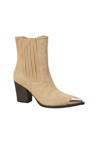Bottines en daim beige avec un bout pointu et un capuchon métallique. Présente des coutures verticales et un talon bloc. Fermeture éclair sur le côté.
