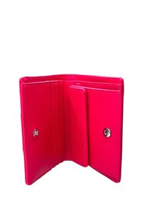 Portafoglio in eco-pelle rosa con più scomparti per carte, chiusura a scatto e superficie lucida. All'interno è spazioso senza scomparti aggiuntivi.