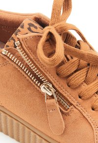 Baskets en suede marron avec une fermeture éclair sur le côté, des accents en dentelle texturée et une semelle crantée. Décorées d'une doublure à imprimé léopard.