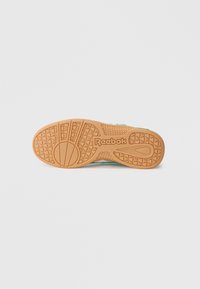 Reebok čevlji s teksturirano gumijasto podplatom. Svetlo aqua zgornji del s tonovnimi poudarki in značilnim Reebok logotipom na podplatu.