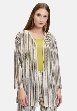 Stribet, let cardigan i beige og sort med v-udskæring, åben front og løse ærmer, parret med en limegrøn top under.