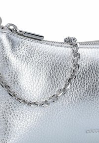Borsa a tracolla argento metallizzato in pelle testurizzata, con chiusura a zip e tracolla in catena argentata. Nome del marchio stampato sul lato.