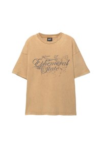 Brun oversized t-shirt lavet af bomuld, med et grafisk print med "Ephemeral State" og stjernesymboler i mørkere nuancer. Rund halsudskæring.