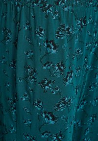 Türkisfarbenes Stoffmaterial mit einem Blumenmuster in dunkleren Farbtönen, glatter Textur und weichem Fall. Der elastische Bund sorgt für einen bequemen Sitz.