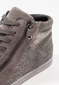 Šedé vysoce postavené tenisky s semišovými a texturovanými serpentýnkovými akcenty. Mají boční zip, šněrování vpředu a kontrastní švy.