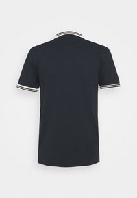 Navy polo shirt with short sleeves, featuring a contrasting white and black striped collar and sleeve edges. Soft cotton fabric.