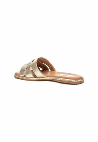Sandal in metallo dorato con una parte superiore strutturata, caratterizzata da tre ritagli. Suola piatta con un'inserto liscio color nocciola e un sottile bordo dorato.