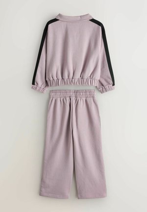 Hanorac scurt mov cu manșete elastice și talie elastică, asociat cu pantaloni largi asortați, cu accente negre pe părțile laterale. Țesătură moale.