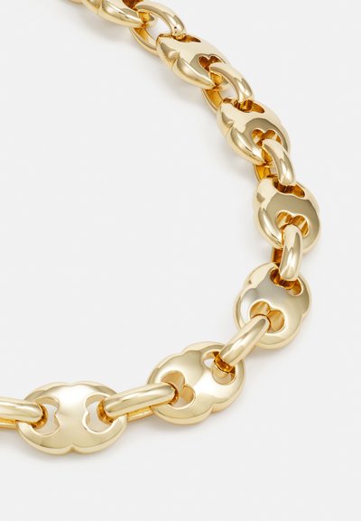Gold chain necklace featuring large, interlocking links with a smooth, shiny finish and decorative cutout designs in each link.