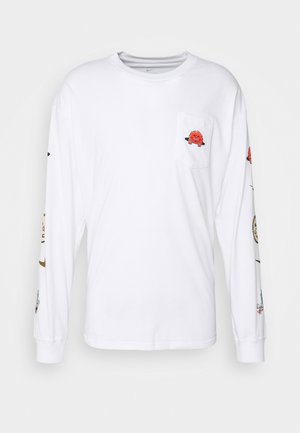 Biała koszula z długim rękawem z małym czerwonym kreskówkowym potworem na kieszeni na piersi oraz różnymi kolorowymi postaciami kreskówkowymi nadrukowanymi wzdłuż rękawów.