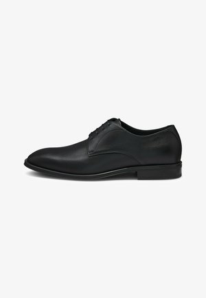 Scarpa da uomo in pelle nera con finitura liscia, punta tonda e design con lacci a cinque fori, arricchita da delicati dettagli di cucitura.