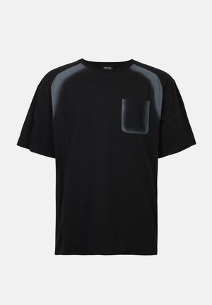 Black t-shirt made of cotton with short sleeves. Features satin-like black shoulder panels and a patch pocket on the left chest.