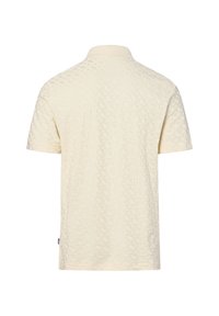 Polo de manga corta crema con un sutil patrón texturizado, cuello acanalado y pequeña etiqueta negra lateral.