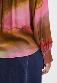 Multicolor blúzka v gradientných odtieňoch ružovej, oranžovej a hnedej, vyrobená z hladkej tkaniny, so dlhými rukávmi a zapínaním na gombíky.
